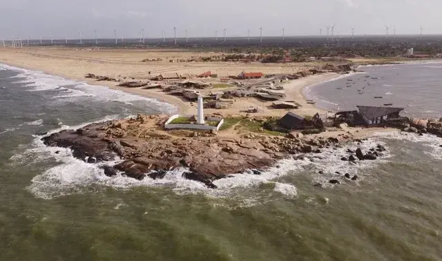 Vista aérea da Praia da Pedra do Sal, com o farol sobre as rochas escuras